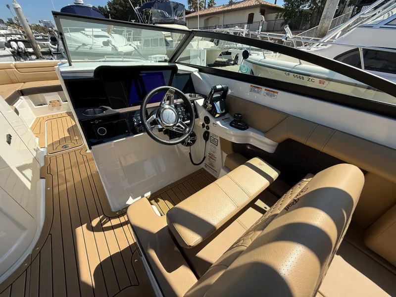 Slide: The Image of 2022 Sea Ray 290 SDX OB boat interior with tan seating and modern dashboard. - 17