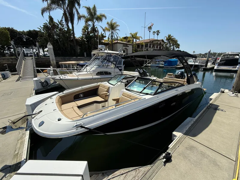 Slide: The Image of 2022 Sea Ray 290 SDX OB boat docked at a marina under clear skies. - 2