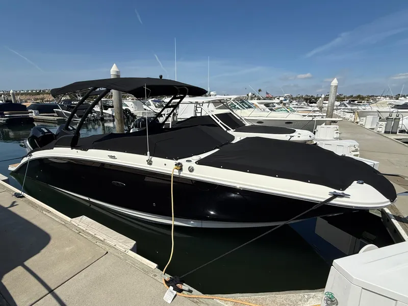 Slide: The Image of 2022 Sea Ray 290 SDX OB boat docked at marina under clear blue sky. - 26