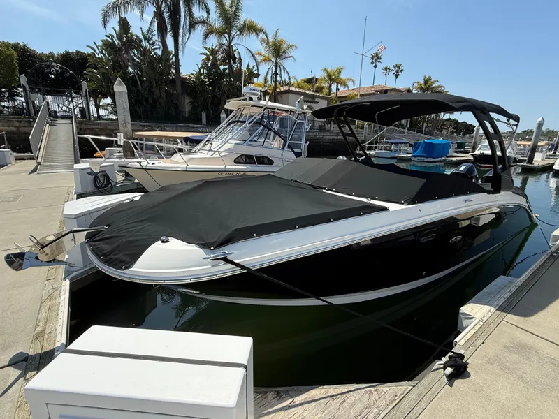 Slide: The Image of 2022 Sea Ray 290 SDX OB boat docked at marina with black cover. - 27