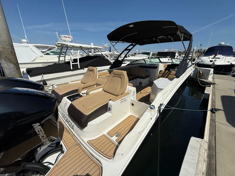 Slide: The Image of 2022 Sea Ray 290 SDX OB boat docked, featuring tan seating and black canopy. - 7