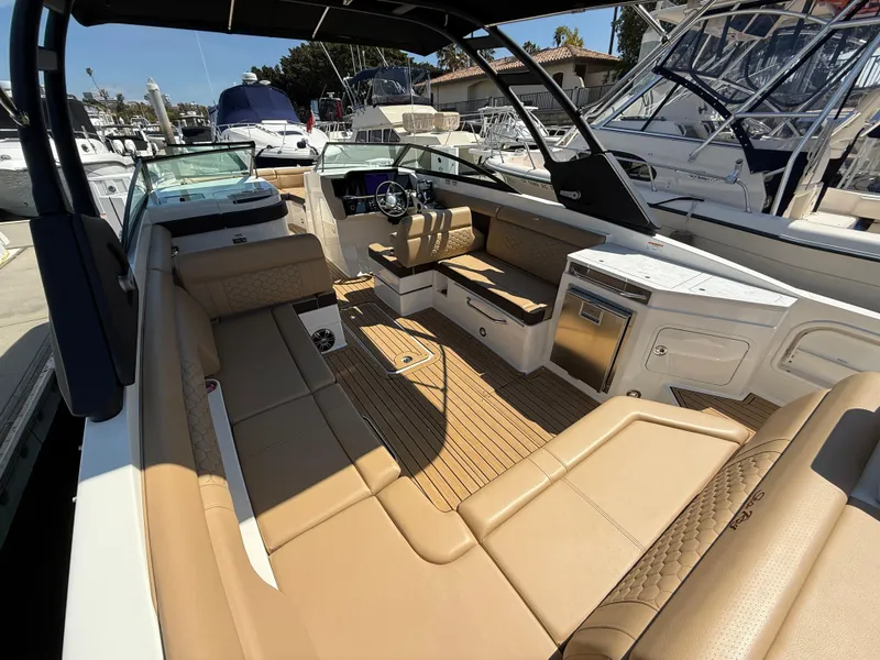 Slide: The Image of 2022 Sea Ray 290 SDX OB boat interior with tan seating and modern amenities. - 9