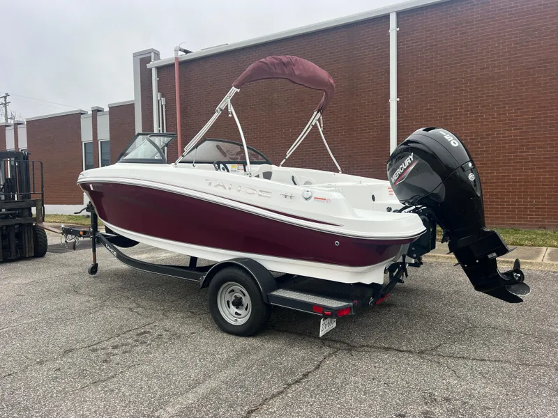 The Image of 2022 Tahoe 185 S boat on trailer, red and white, parked outdoors. - 0