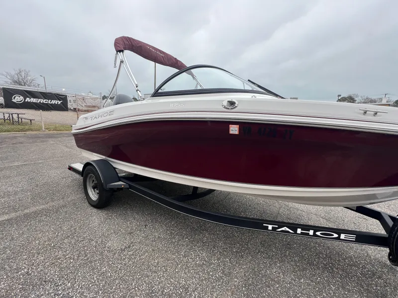 Slide: The Image of 2022 Tahoe 185 S boat on trailer, maroon and white, parked outdoors. - 11