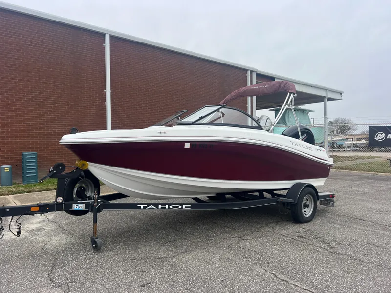 Slide: The Image of 2022 Tahoe 185 S boat with outboard motor on trailer, parked outdoors. - 2