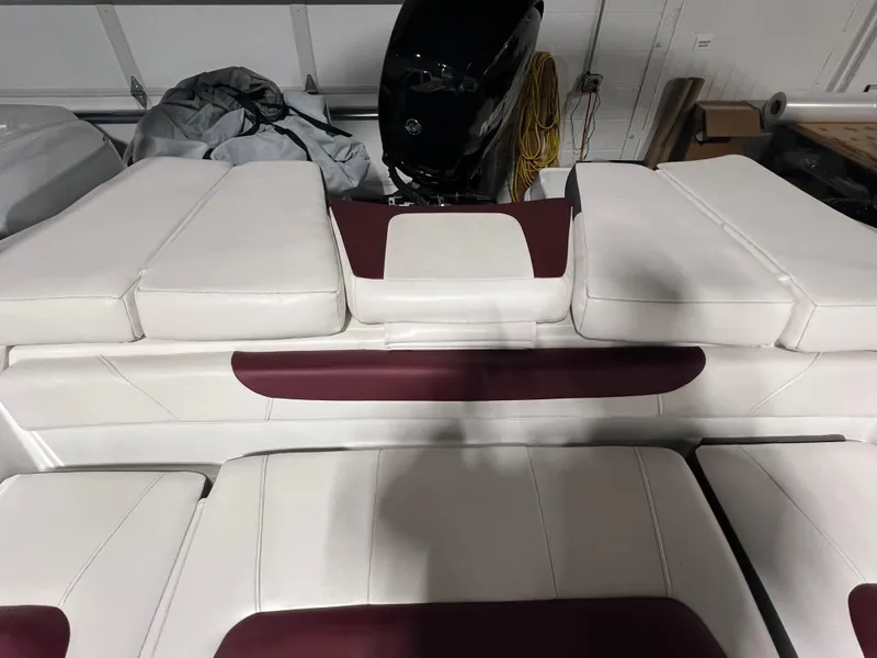 Slide: The Image of 2022 Tahoe 185 S boat interior with white and maroon seating in a garage. - 25
