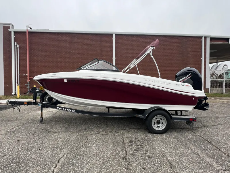 Slide: The Image of 2022 Tahoe 185 S boat on trailer, parked outdoors near a brick building. - 3