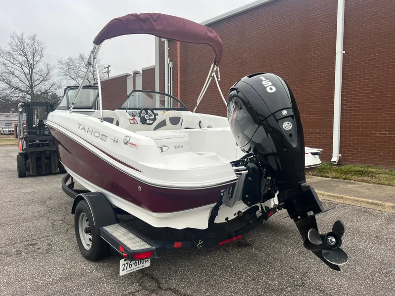 Slide: The Image of 2022 Tahoe 185 S boat on trailer, parked outdoors near a brick building. - 4