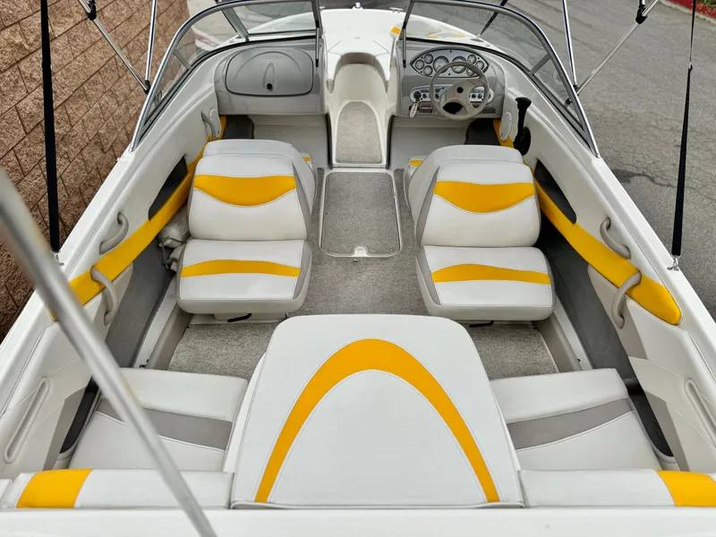 Slide: The Image of 2005 Maxum 1800 SR3 boat interior with yellow and white seating, steering console, and carpeted floor. - 17