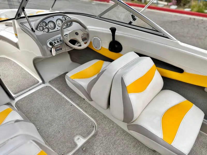 Slide: The Image of 2005 Maxum 1800 SR3 boat interior with yellow and white seating, steering wheel, and dashboard. - 22