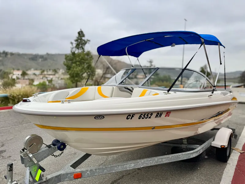 Slide: The Image of 2005 Maxum 1800 SR3 boat with blue canopy on trailer, parked outdoors. - 3