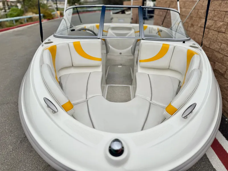 Slide: The Image of 2005 Maxum 1800 SR3 boat with white and yellow seating, docked on pavement. - 9