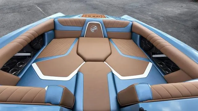 Slide: The Image of 2021 Tigé RZX Class 22 RZX boat interior with blue and brown seating. - 10