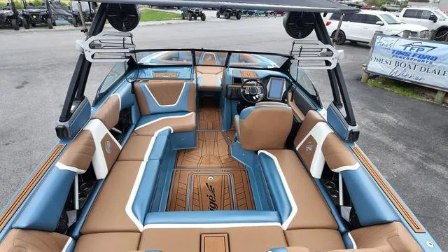 Slide: The Image of 2021 Tigé RZX Class 22 RZX boat interior with blue and tan seating. - 13
