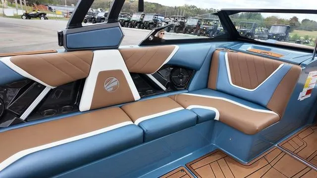 Slide: The Image of 2021 Tigé RZX Class 22 RZX boat interior with blue and brown seating. - 14