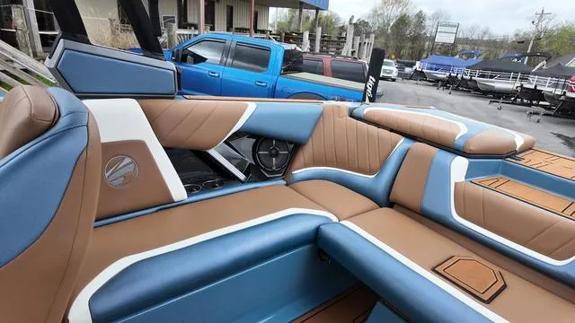 Slide: The Image of 2021 Tigé RZX Class 22 RZX boat interior with blue and brown seating. - 15