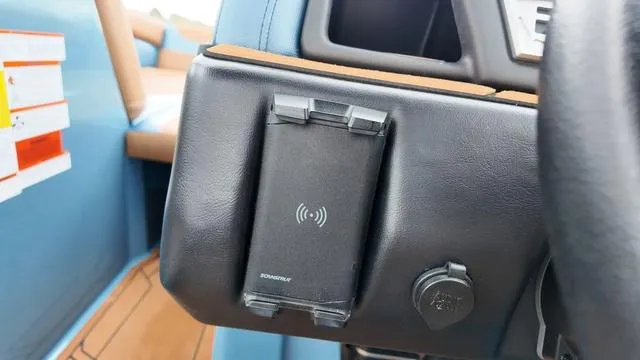 Slide: The Image of 2021 Tigé RZX Class 22 RZX dashboard with wireless phone charger and blue interior. - 20