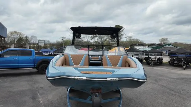 Slide: The Image of 2021 Tigé RZX Class 22 RZX boat, blue exterior, parked outdoors with a truck nearby. - 7