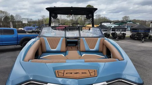 Slide: The Image of 2021 Tigé RZX Class 22 RZX boat with blue and tan interior, parked outdoors. - 8