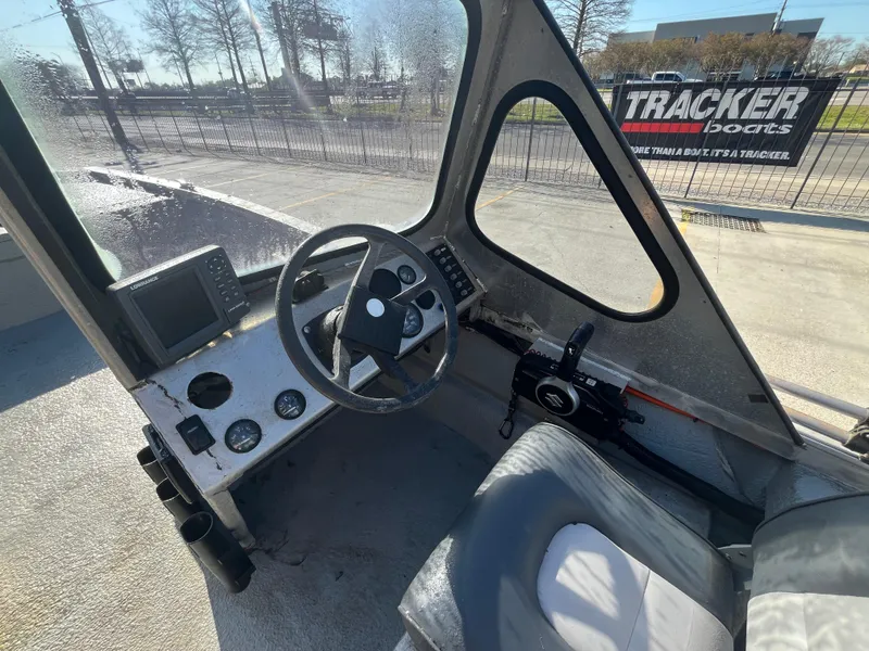 Slide: The Image of 1991 Scully's 18ft Aluminum Walk Thru boat interior with steering wheel and controls. - 13