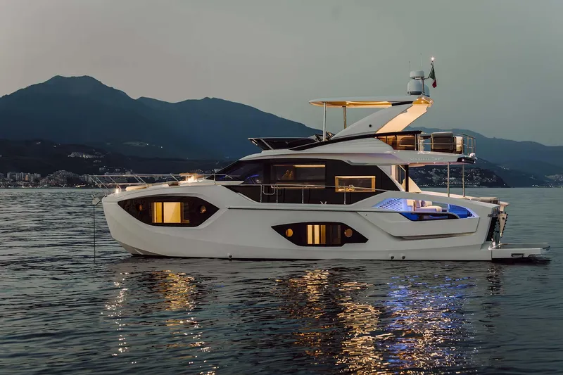 Slide: The Image of Luxurious 2026 Absolute 52 FLY yacht on serene water at dusk. - 0