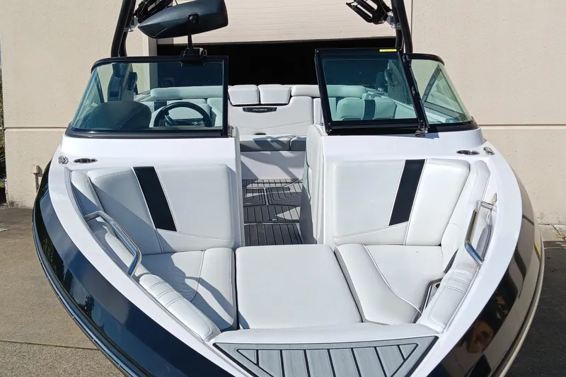 Slide: The Image of 2014 Correct Craft Super Air Nautique 230 boat with sleek white interior and open bow design. - 0