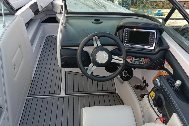 Slide: The Image of 2014 Correct Craft Super Air Nautique 230 boat interior with steering wheel and dashboard. - 10