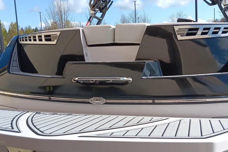 Slide: The Image of 2014 Correct Craft Super Air Nautique 230, rear view, sleek design, black and white finish. - 13