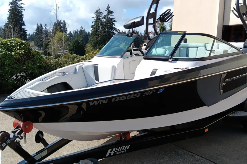 Slide: The Image of 2014 Correct Craft Super Air Nautique 230 boat on trailer, black and white exterior. - 2