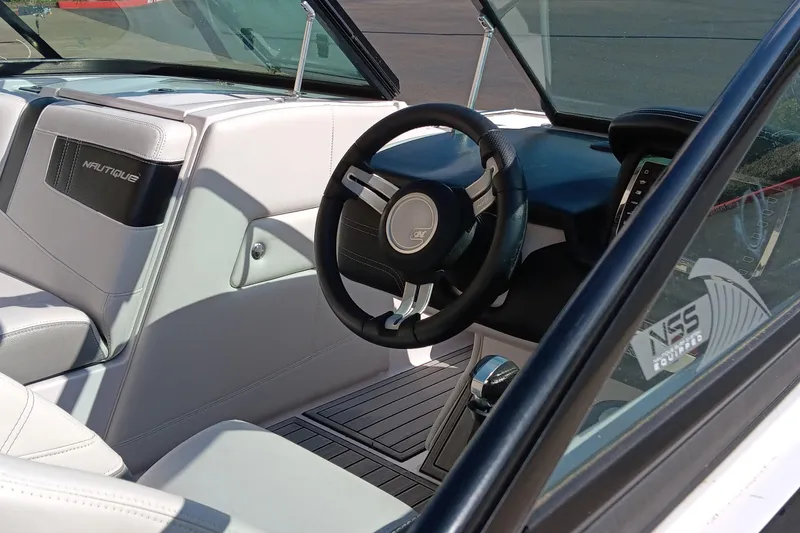 Slide: The Image of Interior of 2014 Correct Craft Super Air Nautique 230 boat, featuring steering wheel and dashboard. - 7
