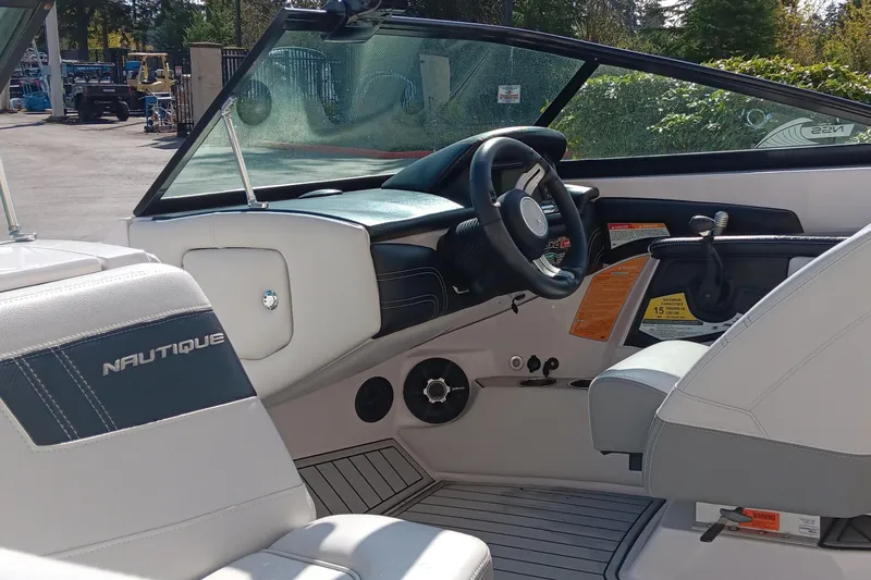 Slide: The Image of 2014 Correct Craft Super Air Nautique 230 boat interior with steering wheel and seating. - 8