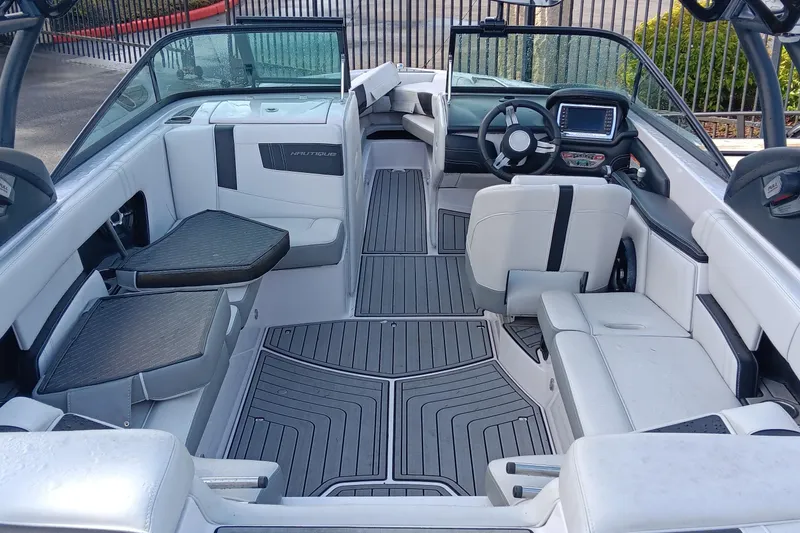 Slide: The Image of 2014 Correct Craft Super Air Nautique 230 interior with sleek seating and modern dashboard. - 9
