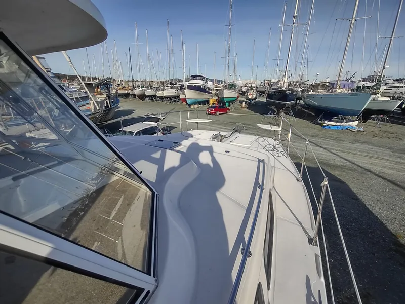 Slide: The Image of 2002 Endeavour Trawlercat 36 on deck, surrounded by boats in a marina. - 21