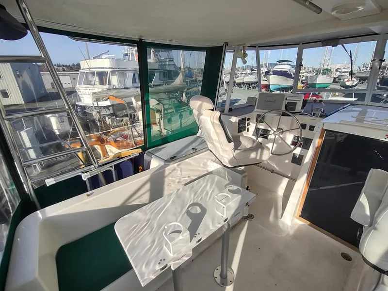 Slide: The Image of Interior view of 2002 Endeavour Trawlercat 36 helm station with marina background. - 32