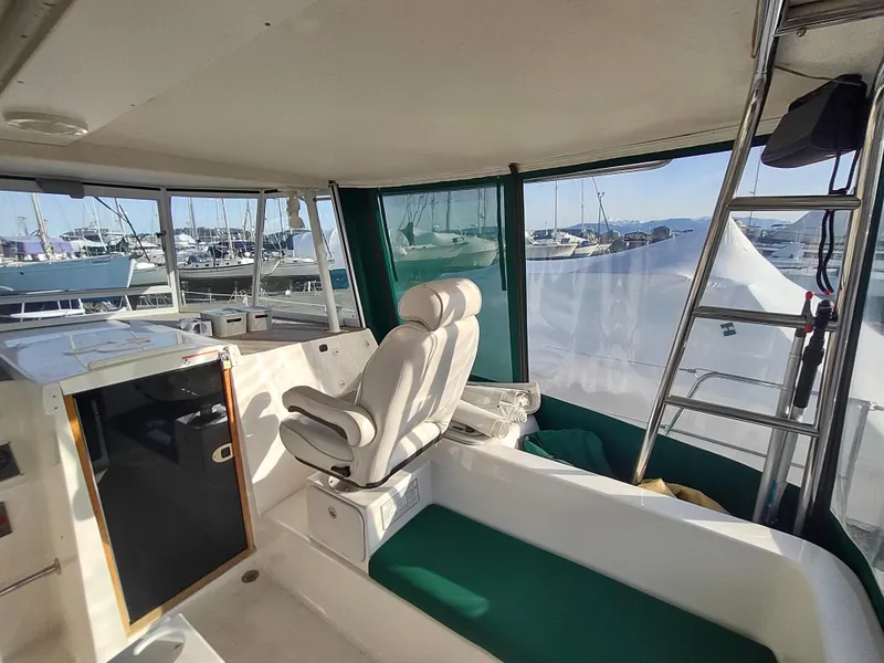 Slide: The Image of 2002 Endeavour Trawlercat 36 interior with helm seat and marina view. - 34