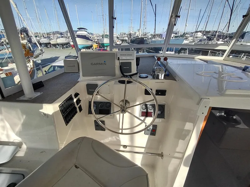 Slide: The Image of Helm of 2002 Endeavour Trawlercat 36 with Garmin navigation, marina view in background. - 35