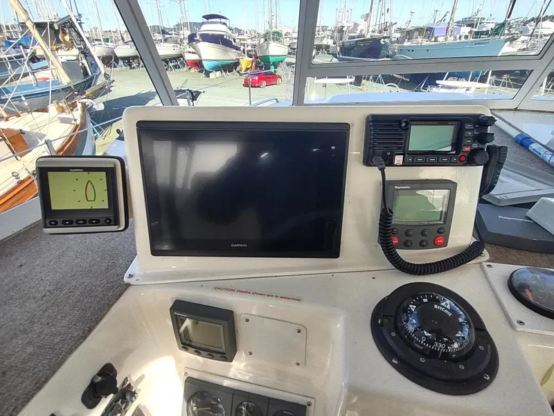 Slide: The Image of Control panel of a 2002 Endeavour Trawlercat 36 with navigation instruments and marina view. - 39