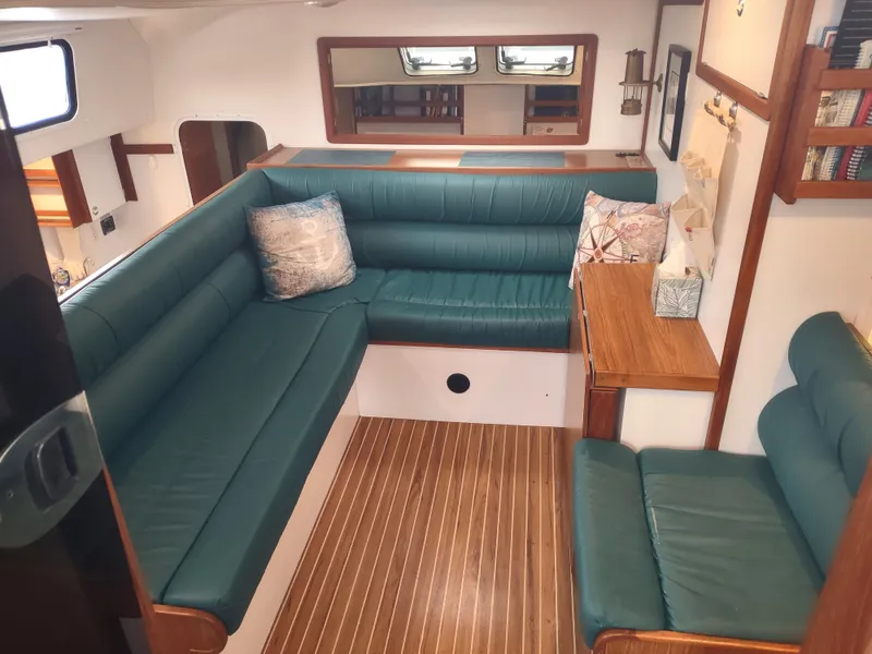 Slide: The Image of Interior of 2002 Endeavour Trawlercat 36 with green seating and wooden accents. - 43