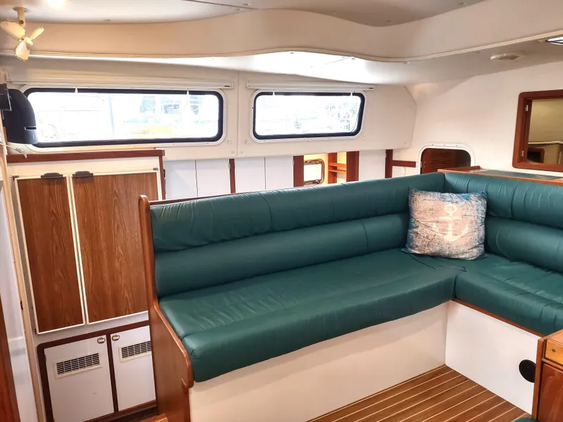 Slide: The Image of Interior of 2002 Endeavour Trawlercat 36 with green seating and wood accents. - 47