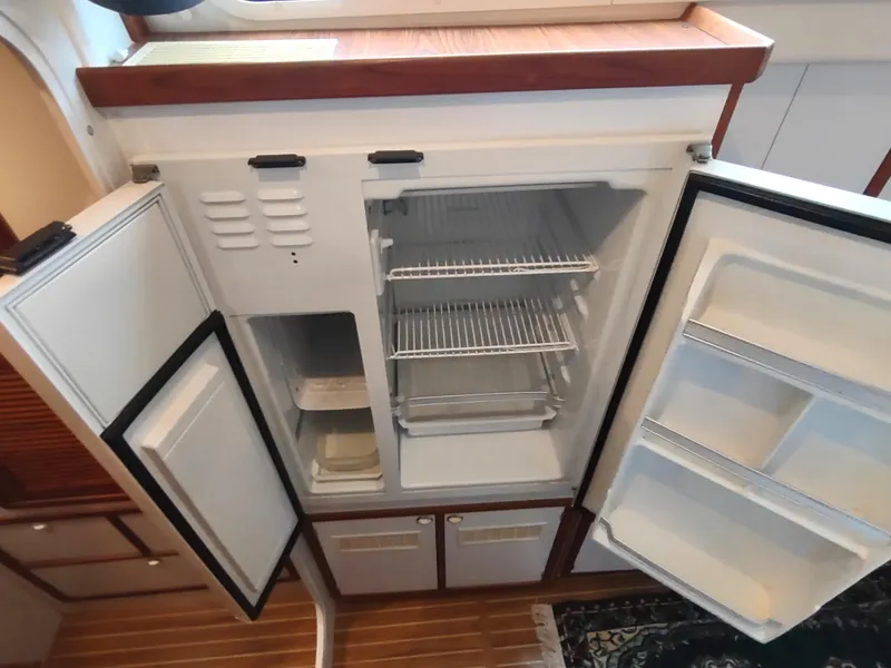 Slide: The Image of 2002 Endeavour Trawlercat 36 galley with open refrigerator and wooden flooring. - 50