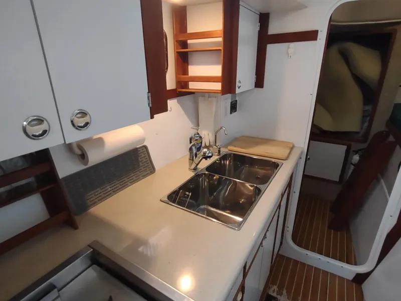 Slide: The Image of Compact kitchen in 2002 Endeavour Trawlercat 36 with dual sinks and wooden cabinetry. - 52