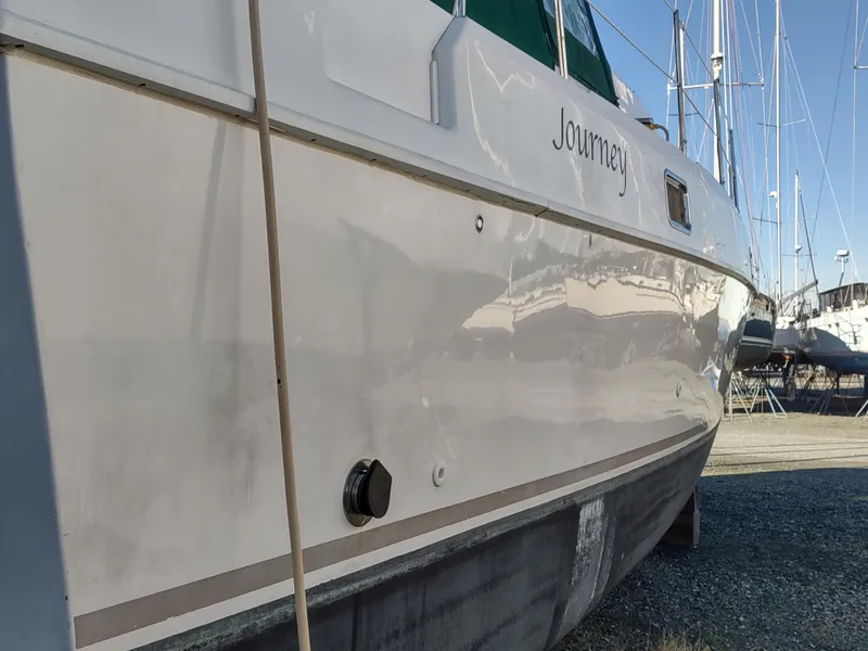 Slide: The Image of 2002 Endeavour Trawlercat 36 boat on land, side view with visible hull and marina background. - 6