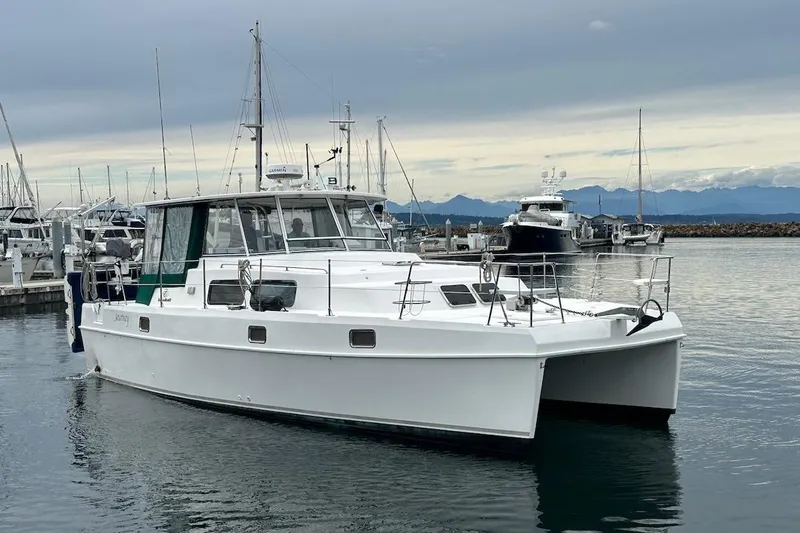 Slide: The Image of 2002 Endeavour Trawlercat 36 in marina, with mountains in the background. - 74