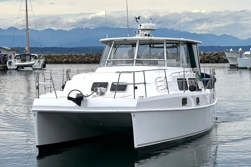 Slide: The Image of 2002 Endeavour Trawlercat 36 cruising in a serene marina setting. - 75