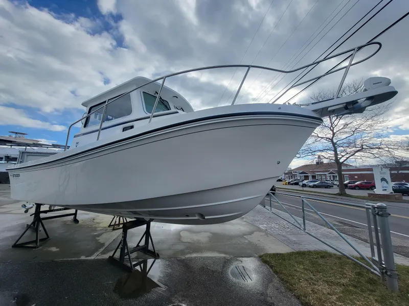 Slide: The Image of 2025 Steiger Craft 255 DV MIAMI boat on display, elevated on stands, under a cloudy sky. - 15