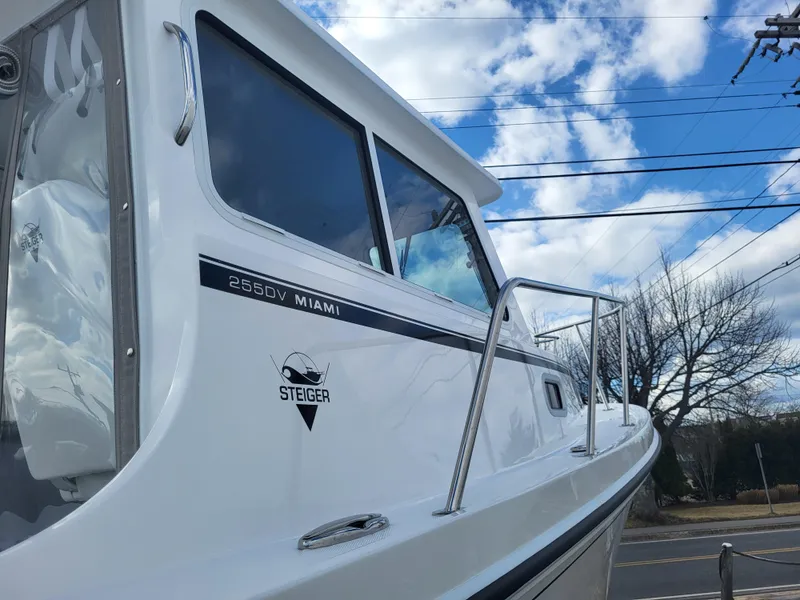 Slide: The Image of 2025 Steiger Craft 255 DV MIAMI boat under a partly cloudy sky. - 16