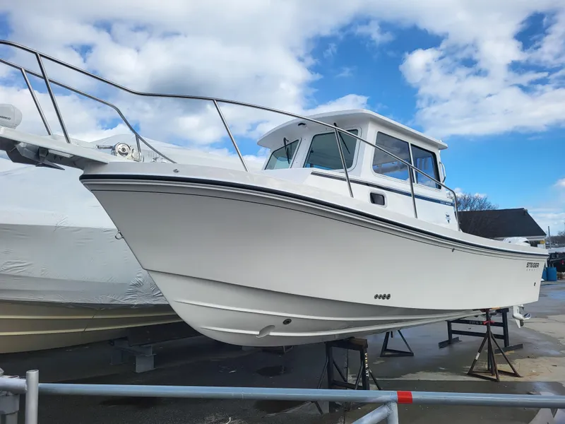 Slide: The Image of 2025 Steiger Craft 255 DV MIAMI boat on display under a partly cloudy sky. - 2