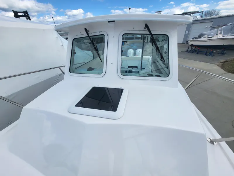 Slide: The Image of 2025 Steiger Craft 255 DV MIAMI boat with white cabin and windows, docked outdoors. - 28