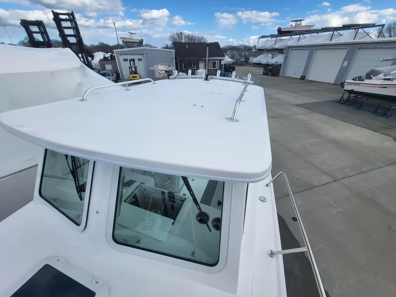 Slide: The Image of 2025 Steiger Craft 255 DV MIAMI boat on display at a marina with clear skies. - 31