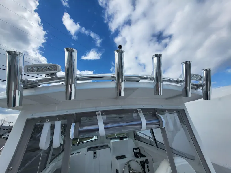 Slide: The Image of 2025 Steiger Craft 255 DV MIAMI boat with rod holders under a cloudy sky. - 34